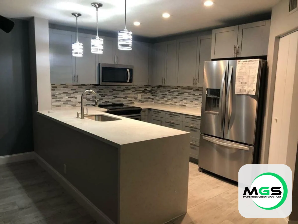 Kitchen remodel with a quartz waterfall island and stainless appliances by Modernize Green Solutions