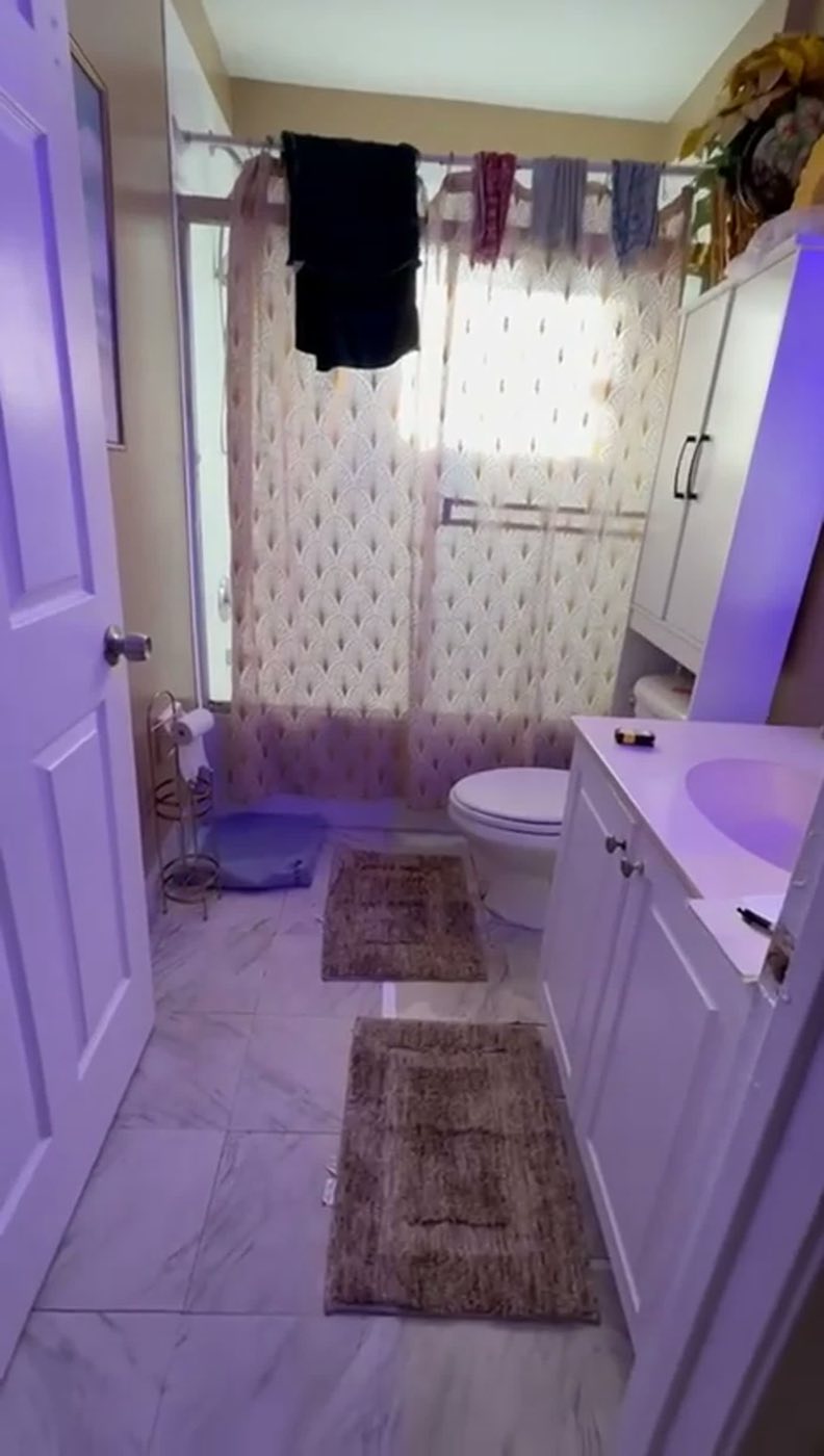 Before: the tub behind a patterned curtain and the old vanity.