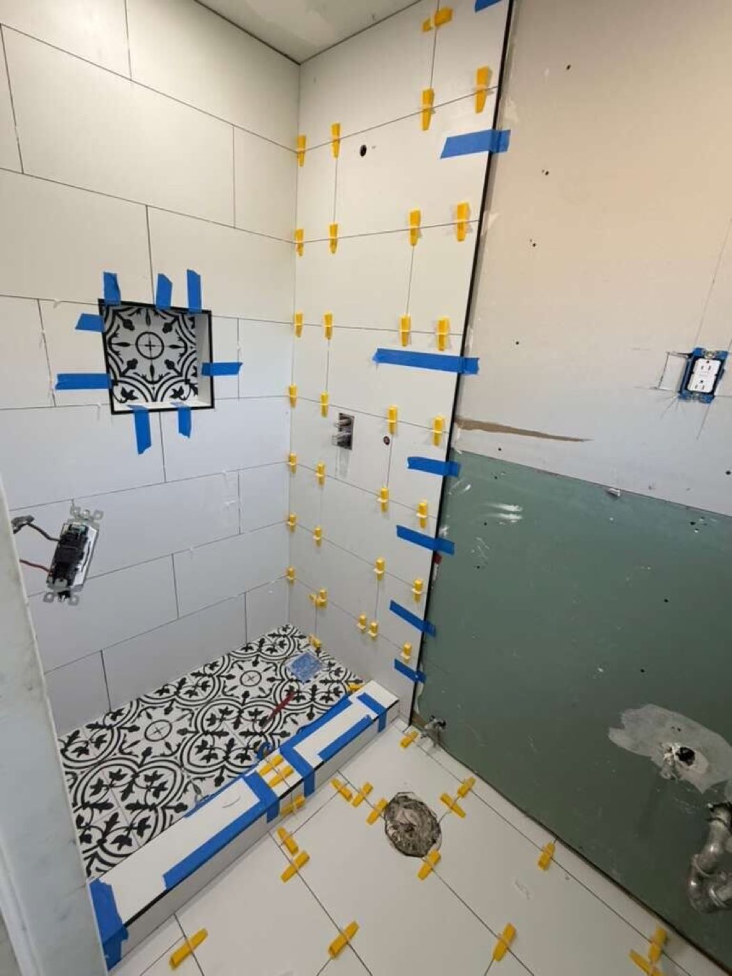 Shower tile set with the patterned accent and floor in place.