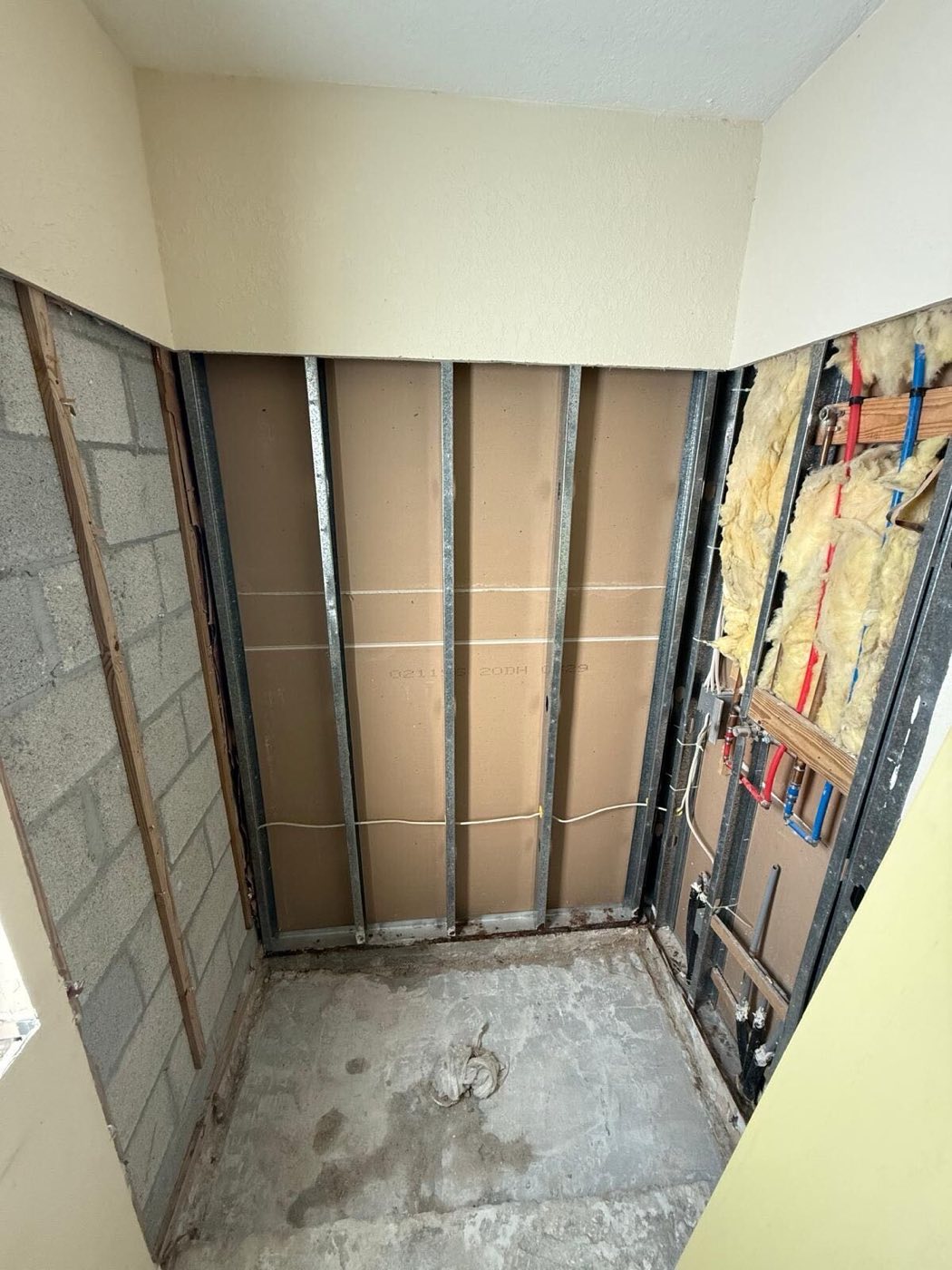 Shower opened to the steel studs, with new supply lines roughed in.