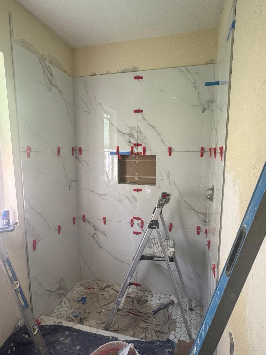 Marble-look wall tile set to a laser line.