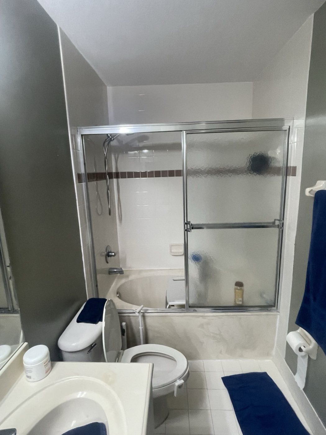 Before: the original tub behind sliding glass doors.