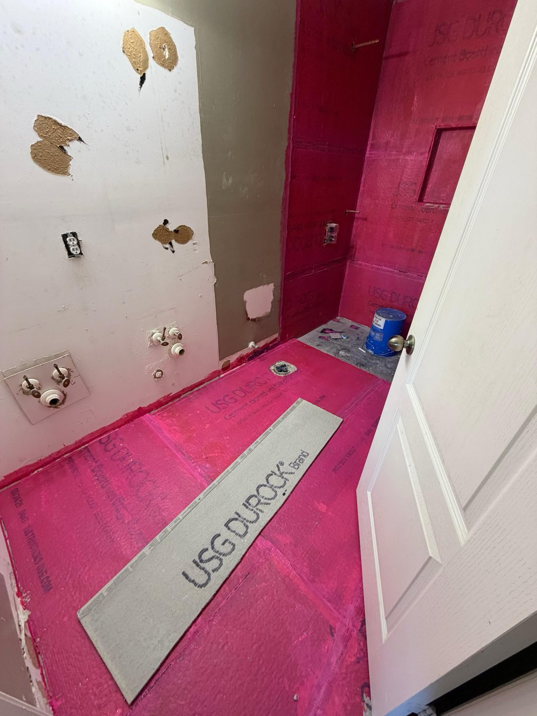 Walls coated in waterproofing membrane, linear drain set, niche framed.