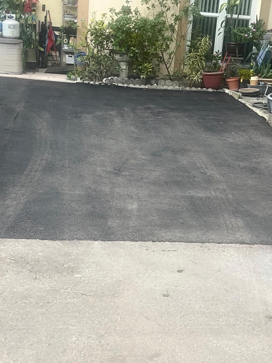 The new asphalt meeting the concrete apron at the street.