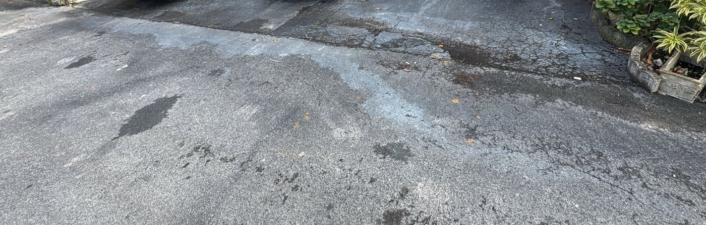 Before: cracked, patched and stained asphalt across the parking area.
