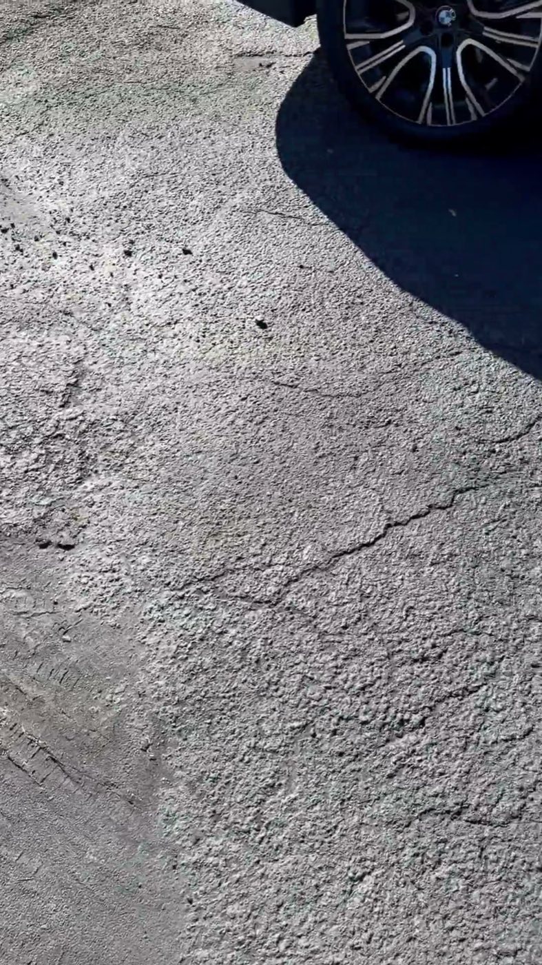 Before: the original asphalt drive, worn and cracked across the surface.