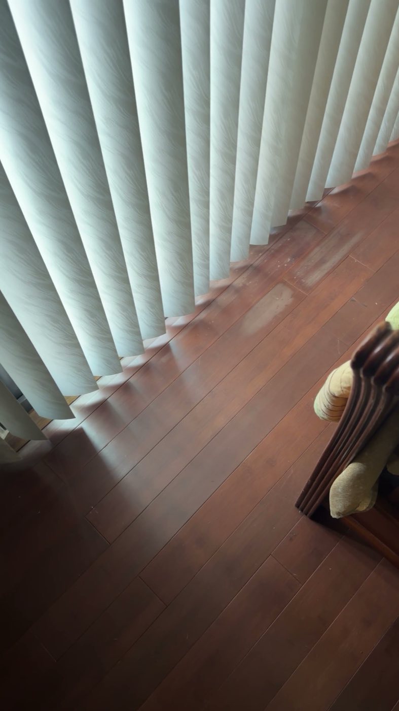 Before: the original dark-stained wood floor along the bedroom wall.