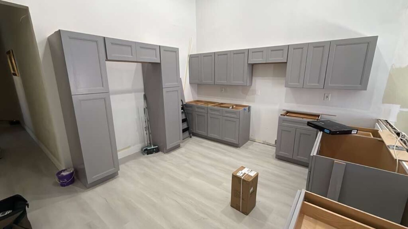 Grey shaker cabinets set around the room on the new floor, counters still to come.