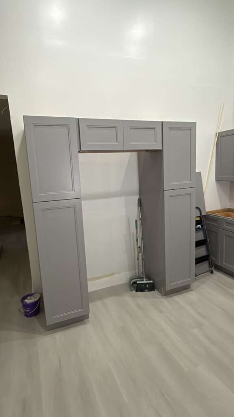 Tall pantry cabinets framing the refrigerator opening.