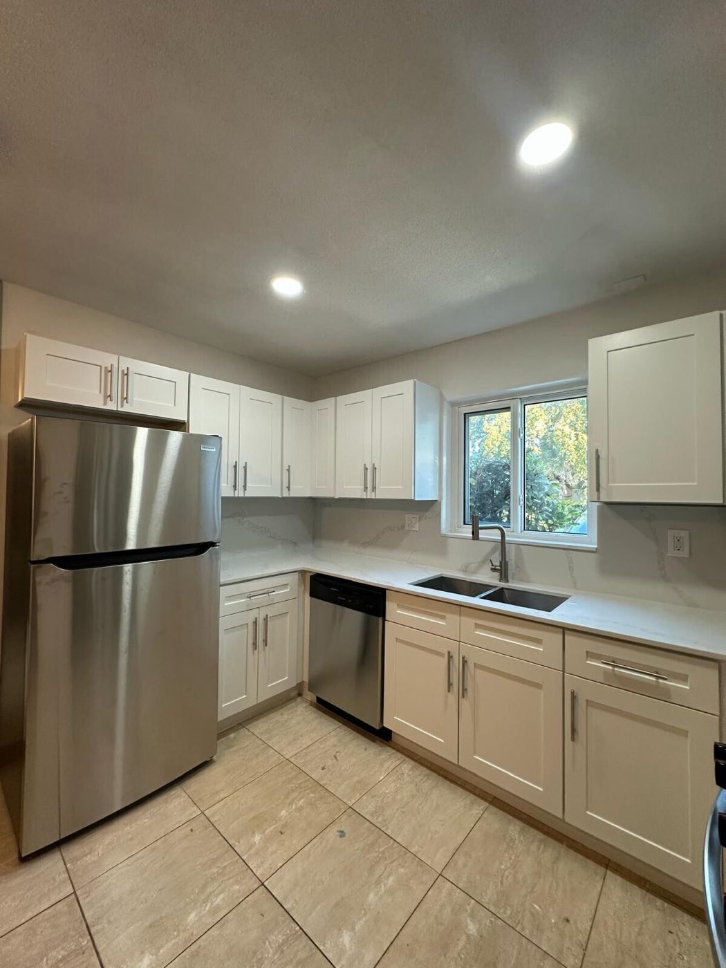 The finished kitchen from the other side: new fridge, dishwasher and sink run.