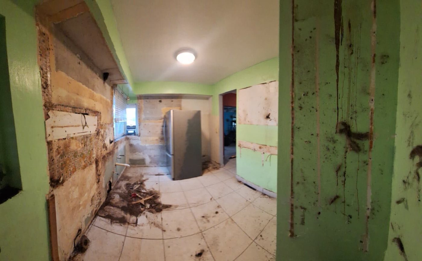 Walls opened to the studs, old cabinets gone, the room cleared to the floor.