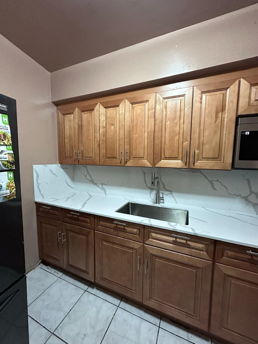 The finished run, wider: new counter, backsplash, sink and over-range microwave.