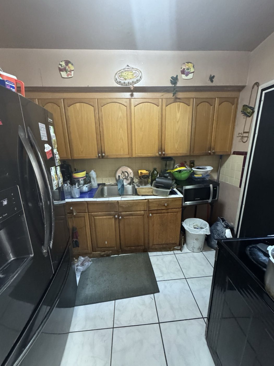 Before: the original kitchen, the same maple cabinets with the old counter and tile backsplash.