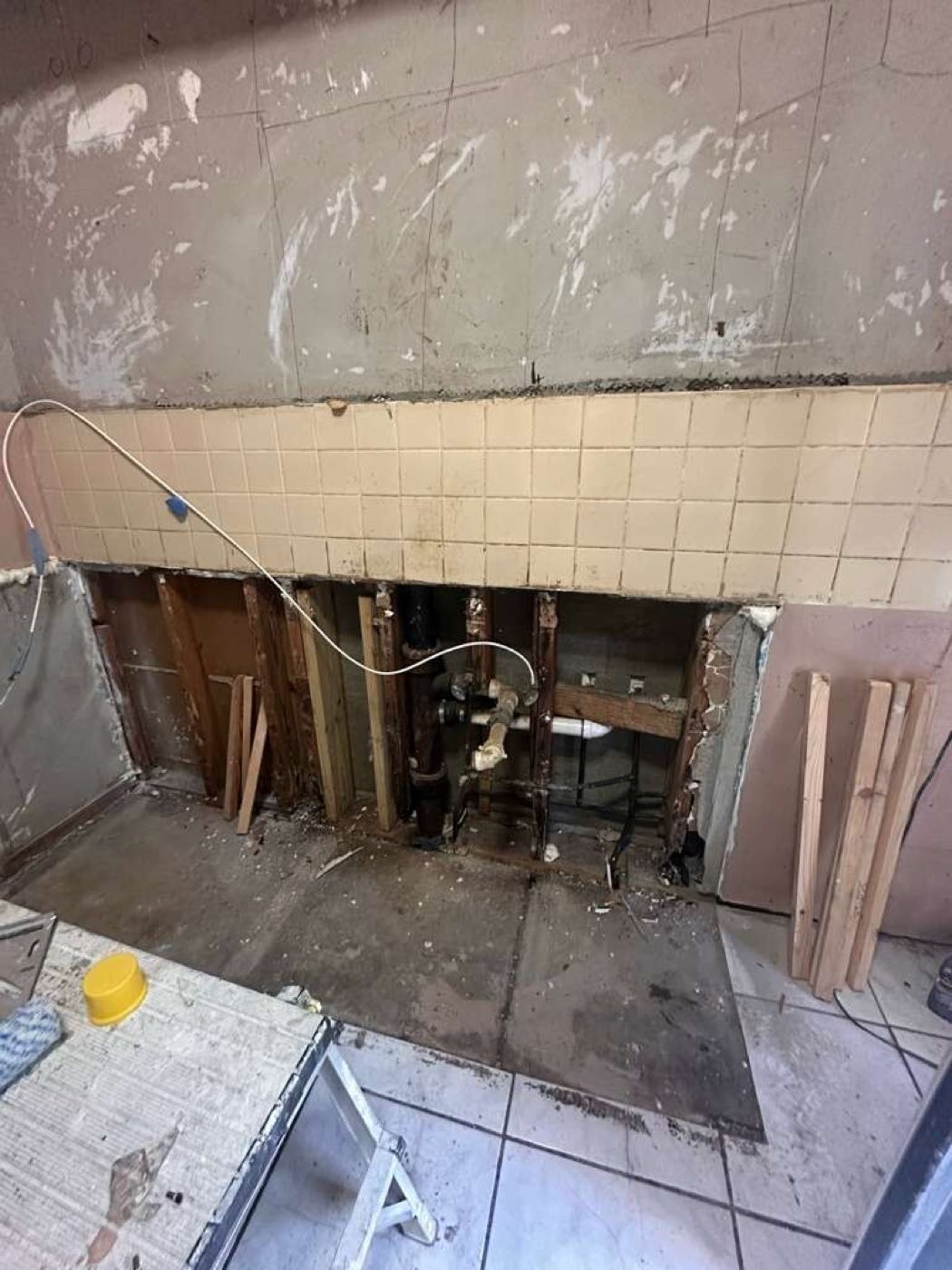 The wall opened back to studs to reach and rework the plumbing.