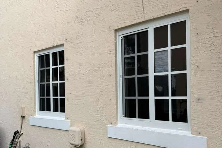 New impact windows on the stucco wall of a South Florida home, installed by MGS